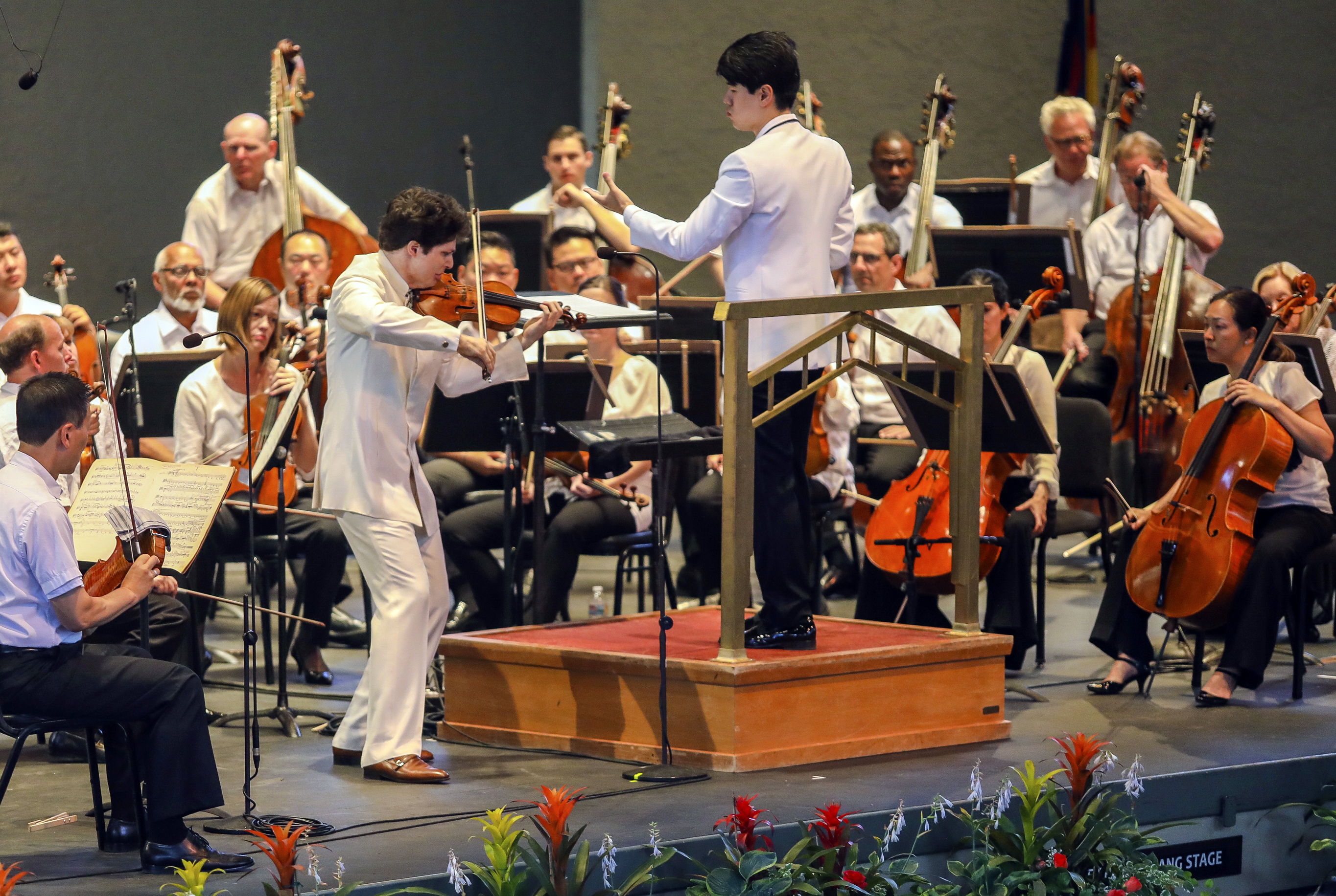 FILE - The Philadelphia Orchestra, conducted by Kensho Watanabe, and Musical America's 2018 Instrumentalist of the Year, Augustin Hadelich, on violin, performs during the second-to-last performance of the Philadelphia Orchestra of the Bravo! Vail season in Vail, Colo., on July 13, 2018. In a deal announced Saturday night, Oct. 21, 2023, musicians of the Philadelphia Orchestra and the Philadelphia Orchestra Association have ratified a collective bargaining agreement calling for minimum salaries to increase by 15.8% over three years. (Chris Dillmann/Vail Daily via AP, File)